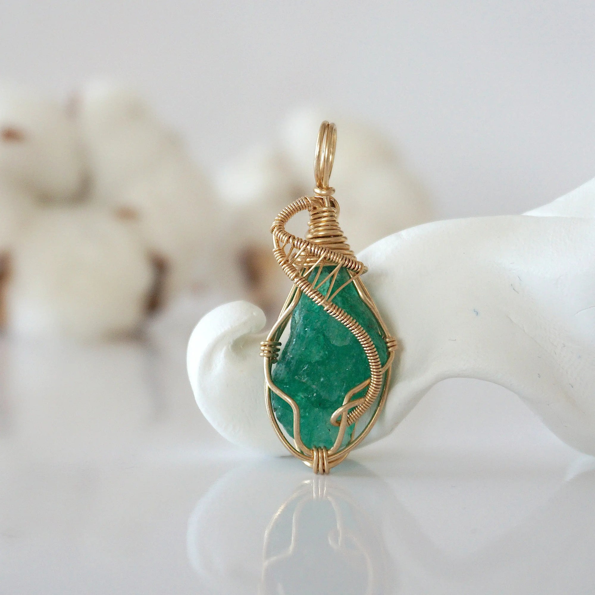 Detailed front view of raw emerald pendant in 14k gold filled. Unique wire wrapped May birthstone jewelry by Designs by Nature Gems.