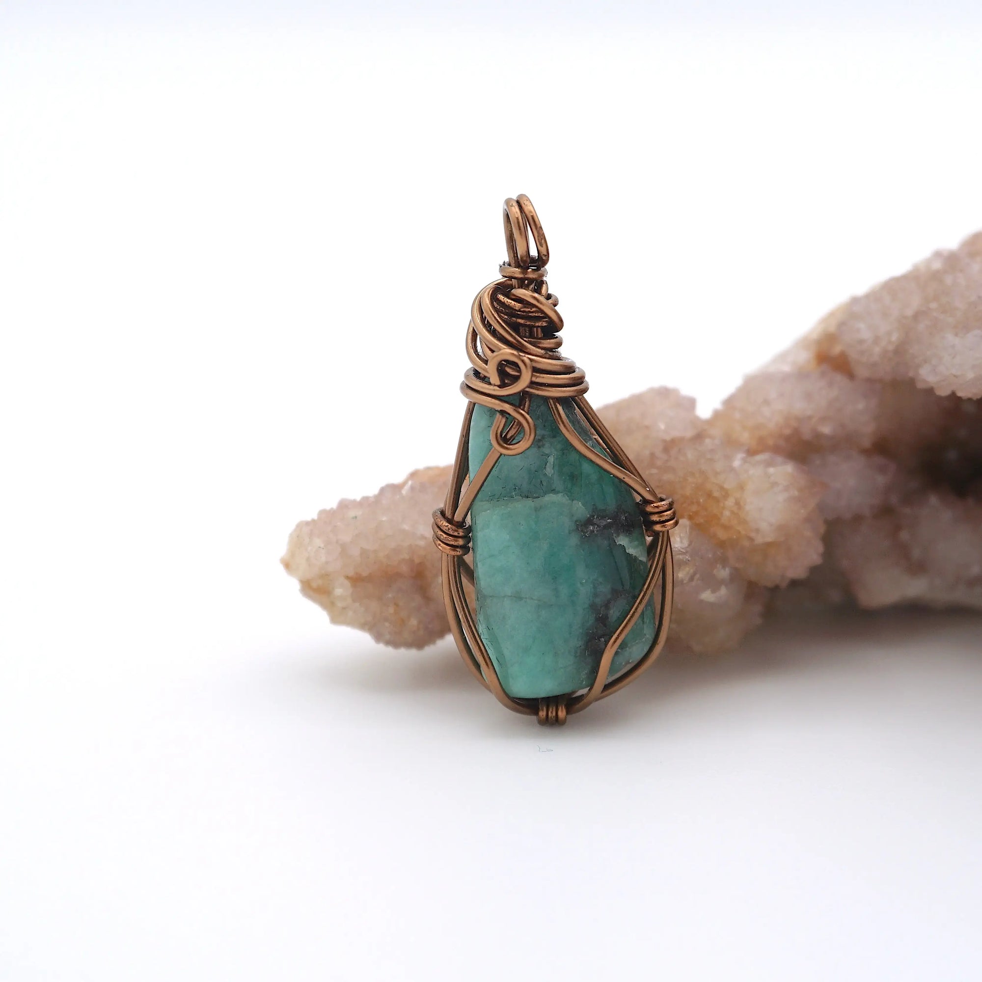 Back view of natural emerald pendant highlighting artisan wire wrapping in antique bronze copper.