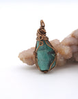 Back view of natural emerald pendant highlighting artisan wire wrapping in antique bronze copper.