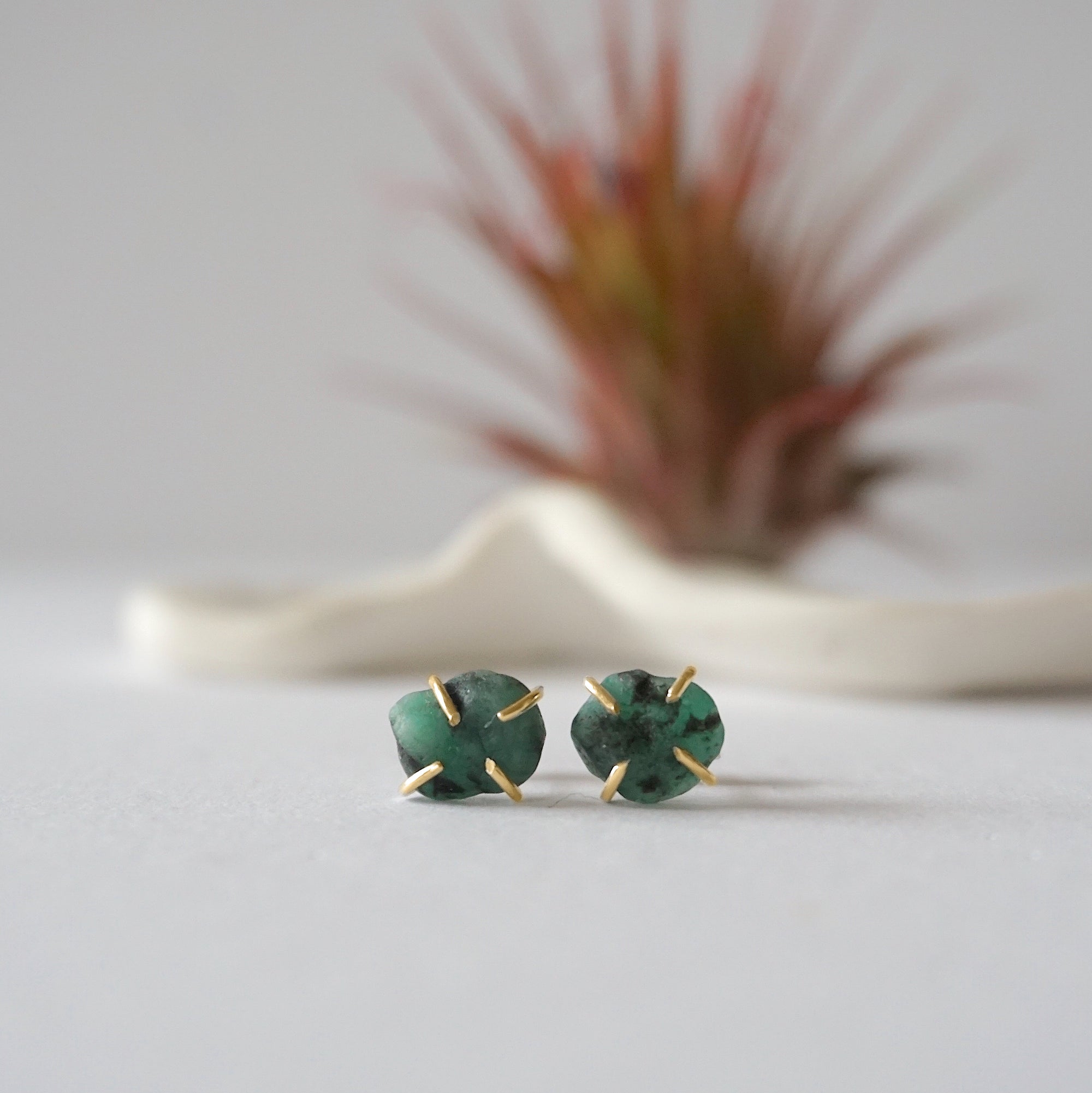 Front view of raw emerald stud earrings in 14k gold vermeil with natural emerald stones and handcrafted prong setting