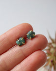 Natural raw emerald stud earrings in 14k gold vermeil shown in hand to display size and organic stone variation