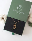 Raw garnet necklace in 14k gold filled displayed in branded Designs by Nature Gems jewelry box. Artisan January birthstone gift for women.