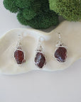 Three raw garnet necklaces showing natural crystal variations in handmade wire wrapped pendants
