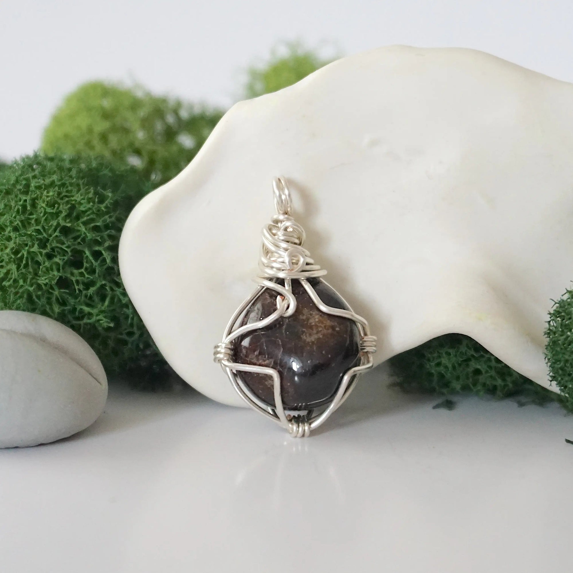 Back angle look at simple raw garnet pendant with silver wire wrapping