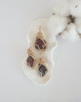 Three raw garnet pendants in 14k gold filled, showing natural variation in size, shape, and color. Handcrafted January birthstone jewelry by Designs by Nature Gems.