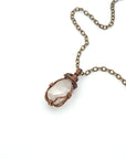 Raw Herkimer diamond necklace wrapped in antique bronze copper, detailed view of handmade April birthstone pendant for all genders.