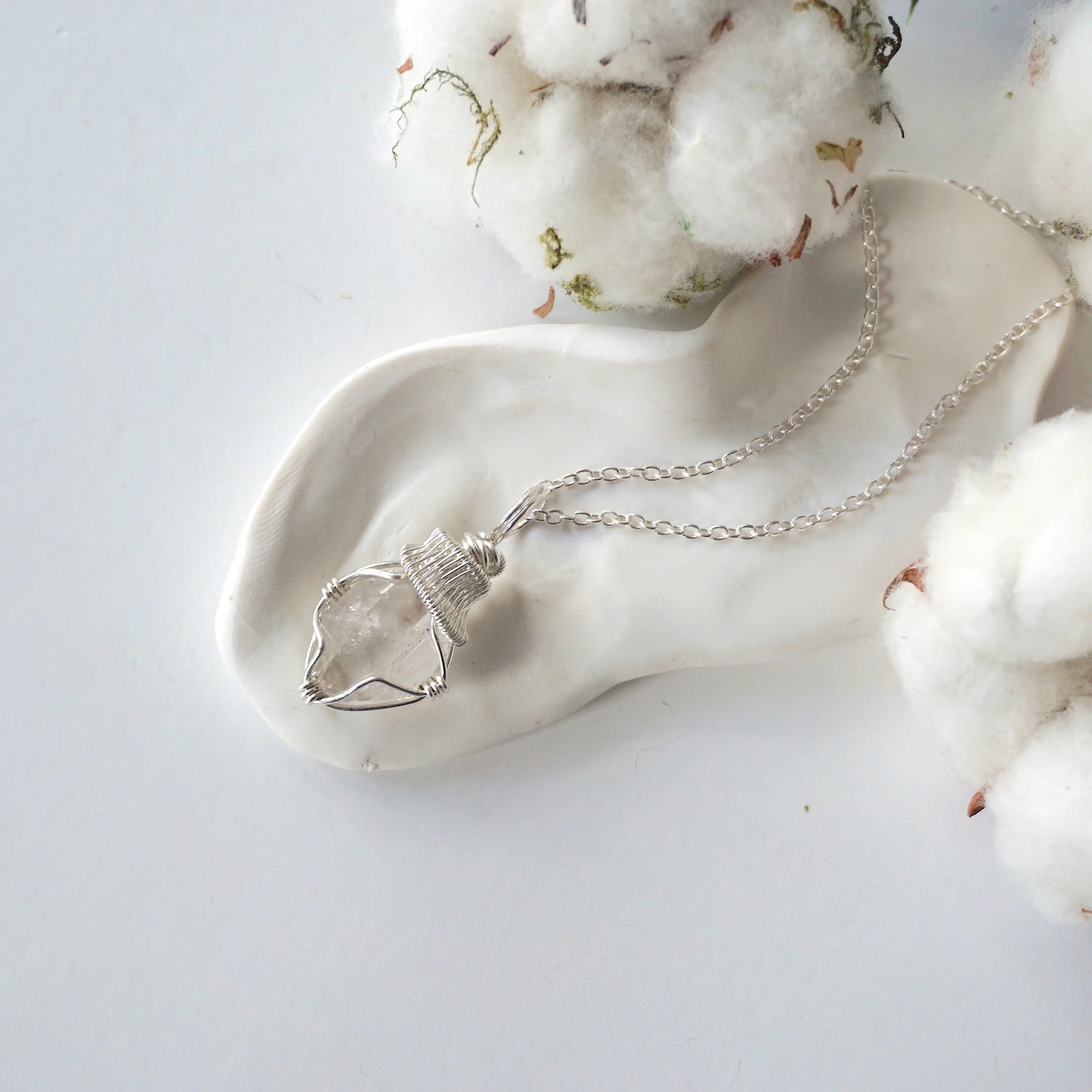 Detailed view of raw Herkimer diamond pendant on 925 sterling silver chain for women with handmade artisan wrapping.