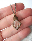 Raw Herkimer diamond necklace for women shown in hand for size reference with antique bronze copper wire wrapping.