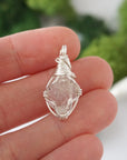 Simple raw Herkimer diamond pendant shown in hand for size reference