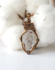 Front view of raw Herkimer diamond pendant for women with detailed artisan wire wrapping in antique bronze copper.