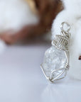 Left angle view of raw Herkimer diamond necklace for women highlighting artisan wire wrapping in 925 sterling silver.