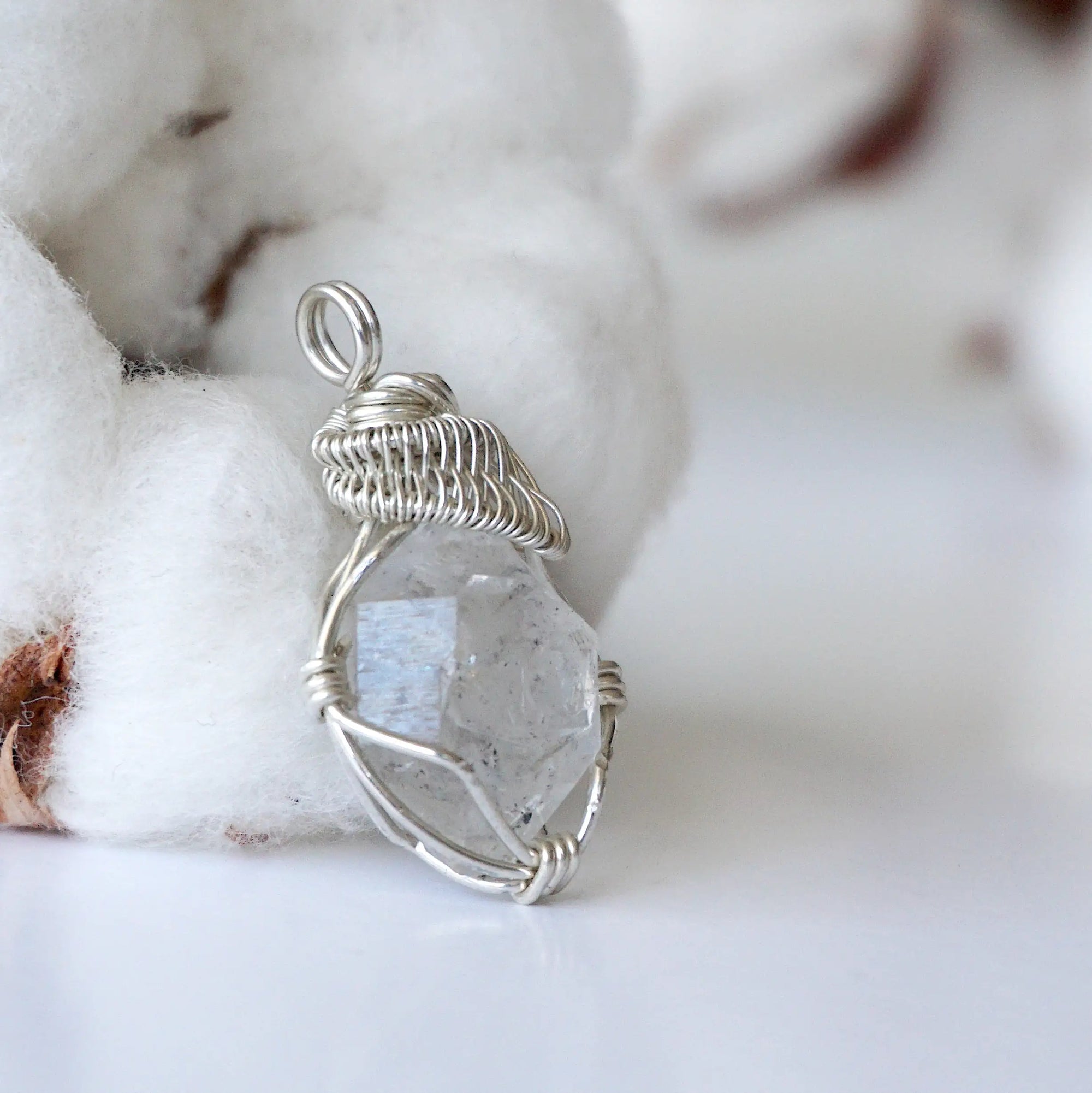 Right angle view of handmade Herkimer diamond pendant for women showing 925 sterling silver wire artistry.
