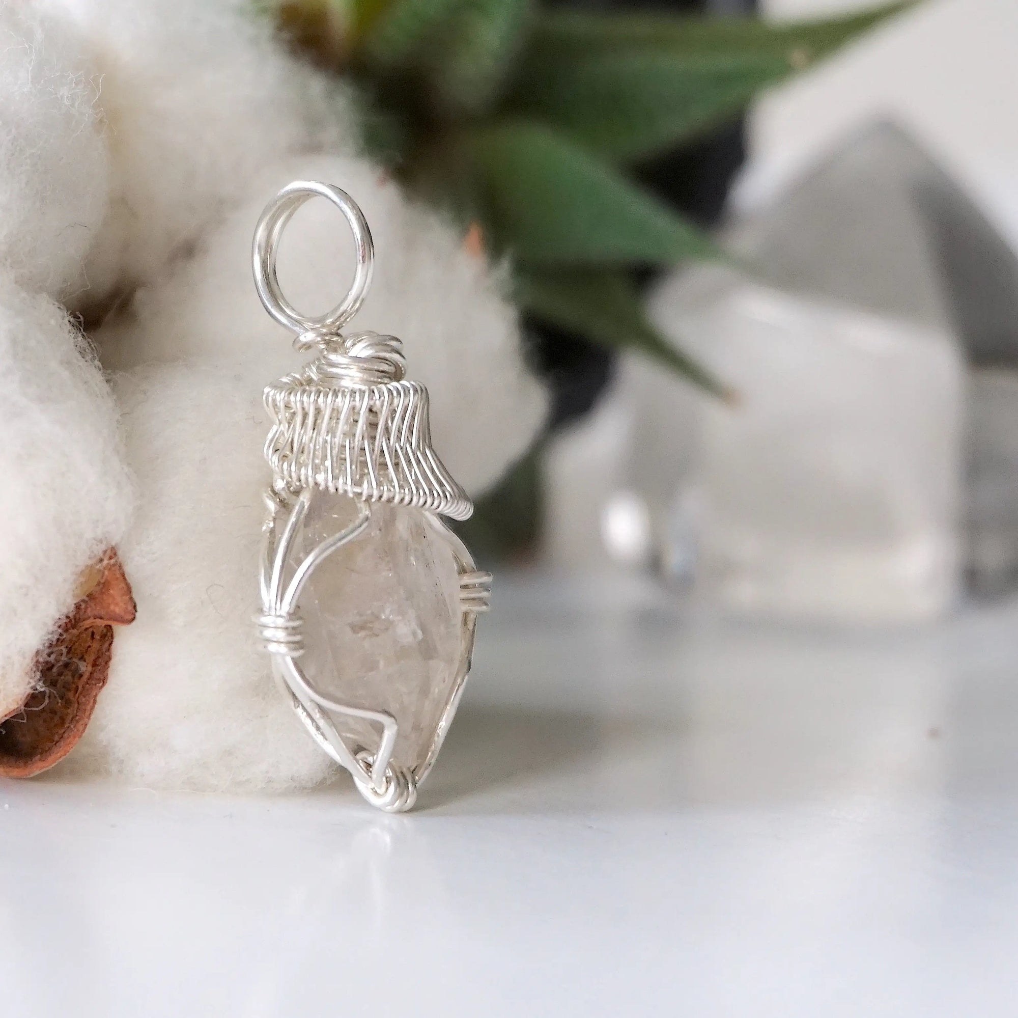 Right angle view of handmade Herkimer diamond pendant for women showing 925 sterling silver wire artistry.