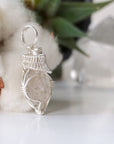 Right angle view of handmade Herkimer diamond pendant for women showing 925 sterling silver wire artistry.