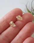 Raw Herkimer diamond stud earrings shown in hand for size reference in 14k gold vermeil prong settings.