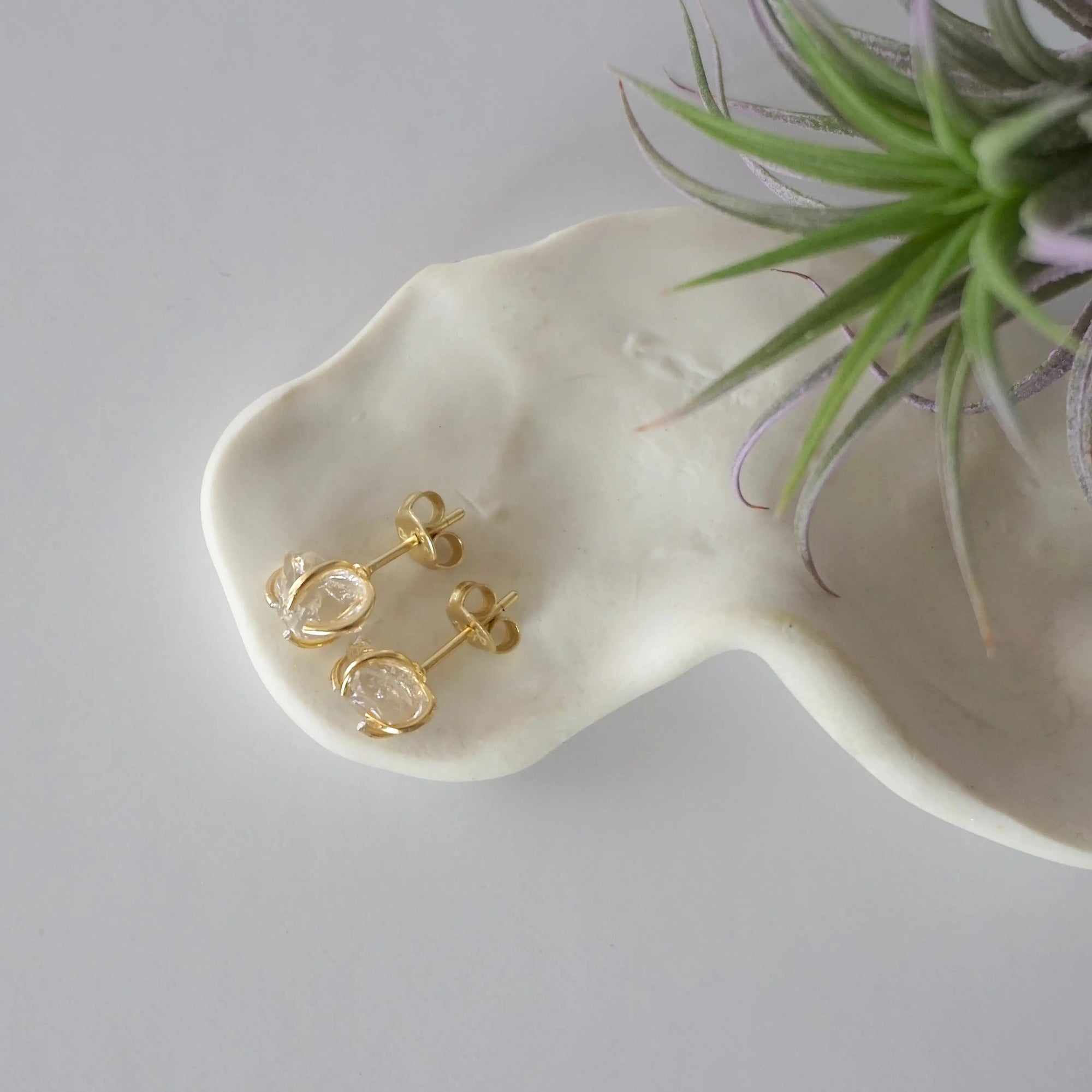 Top view of raw Herkimer diamond stud earrings in 14k gold vermeil with natural crystal shape.