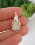 Simple raw opal pendant shown in hand for size reference