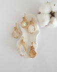 Five raw opal pendants in 14k gold filled, showing natural variation in size, shape, and color. Handcrafted October birthstone jewelry by Designs by Nature Gems.
