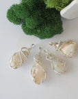 Four raw Ethiopian opal pendants showing natural variation in stone size, shape, and colour play — each one of a kind, October birthstone, 925 sterling silver wire wrapped, Designs by Nature Gems