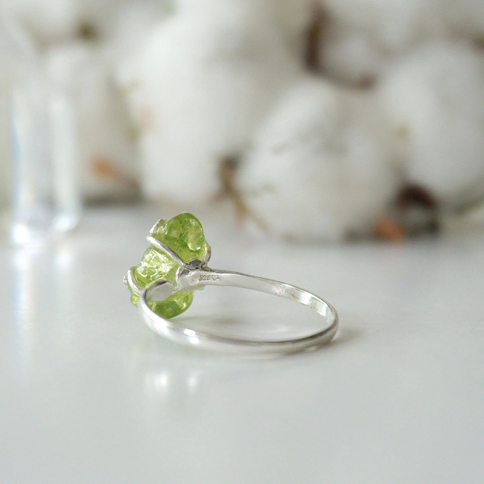 Back view of raw peridot adjustable ring showing open-back 925 sterling silver band — fits US sizes 4–10, handmade artisan August birthstone crystal ring for women
