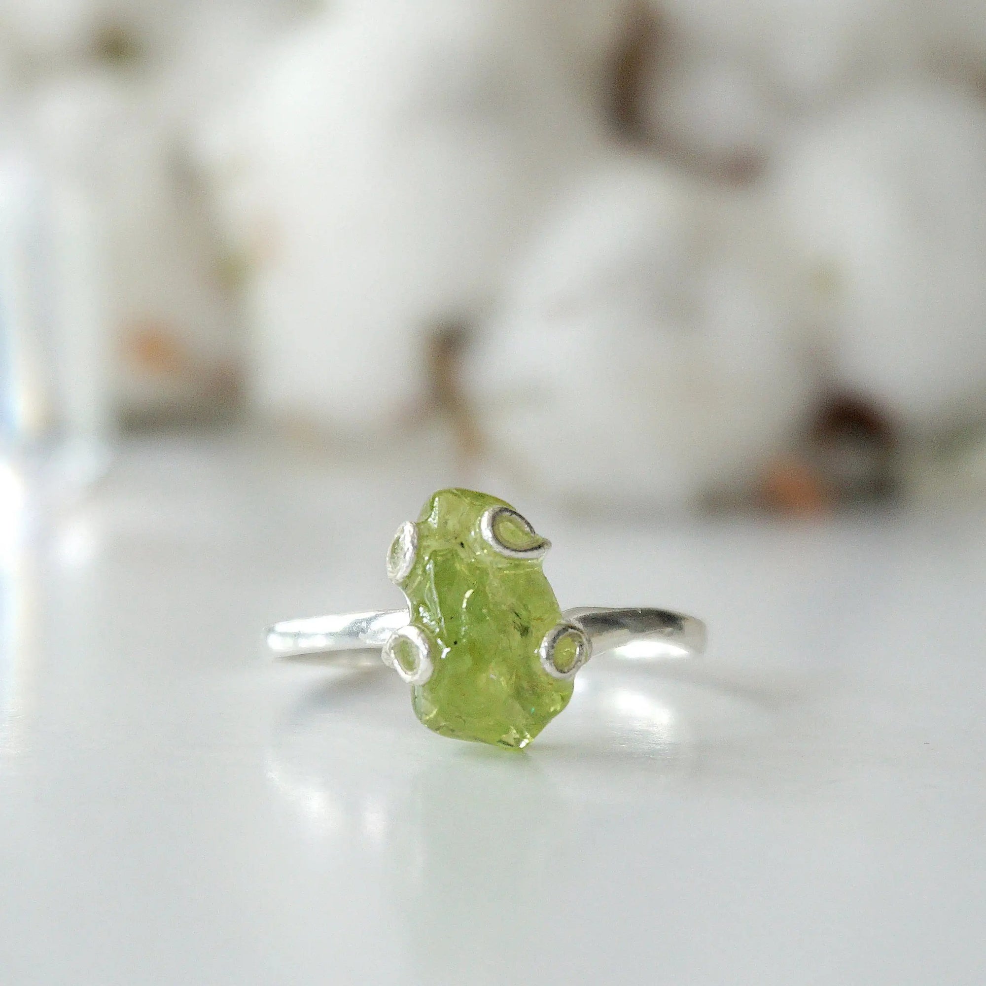 Front detail of raw peridot adjustable ring — vivid olive green natural crystal in 925 sterling silver artisan setting, handcrafted August birthstone ring for women