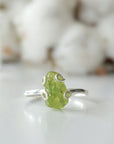 Front detail of raw peridot adjustable ring — vivid olive green natural crystal in 925 sterling silver artisan setting, handcrafted August birthstone ring for women