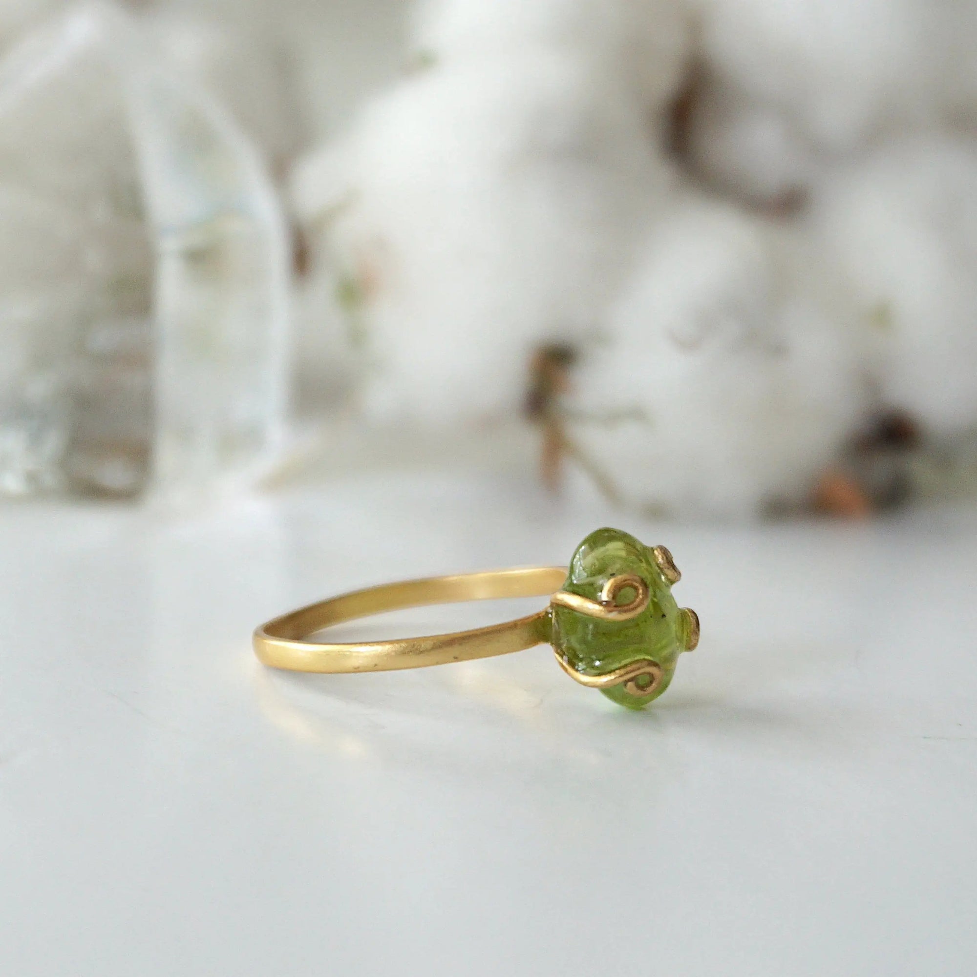 Left side angle of raw peridot adjustable ring — 14k gold vermeil artisan wire setting and smooth band detail, handcrafted August birthstone crystal ring for women