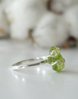 Left side angle of raw peridot adjustable ring — 925 sterling silver artisan wire setting and smooth band detail, handcrafted August birthstone crystal ring for women