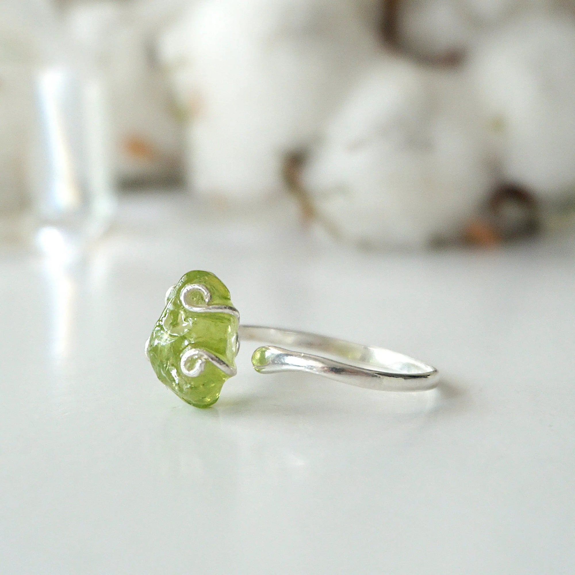 Right side angle of raw peridot adjustable ring — 925 sterling silver wire spiral setting and smooth band profile, dainty handcrafted August birthstone crystal ring for women