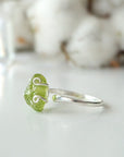 Right side angle of raw peridot adjustable ring — 925 sterling silver wire spiral setting and smooth band profile, dainty handcrafted August birthstone crystal ring for women