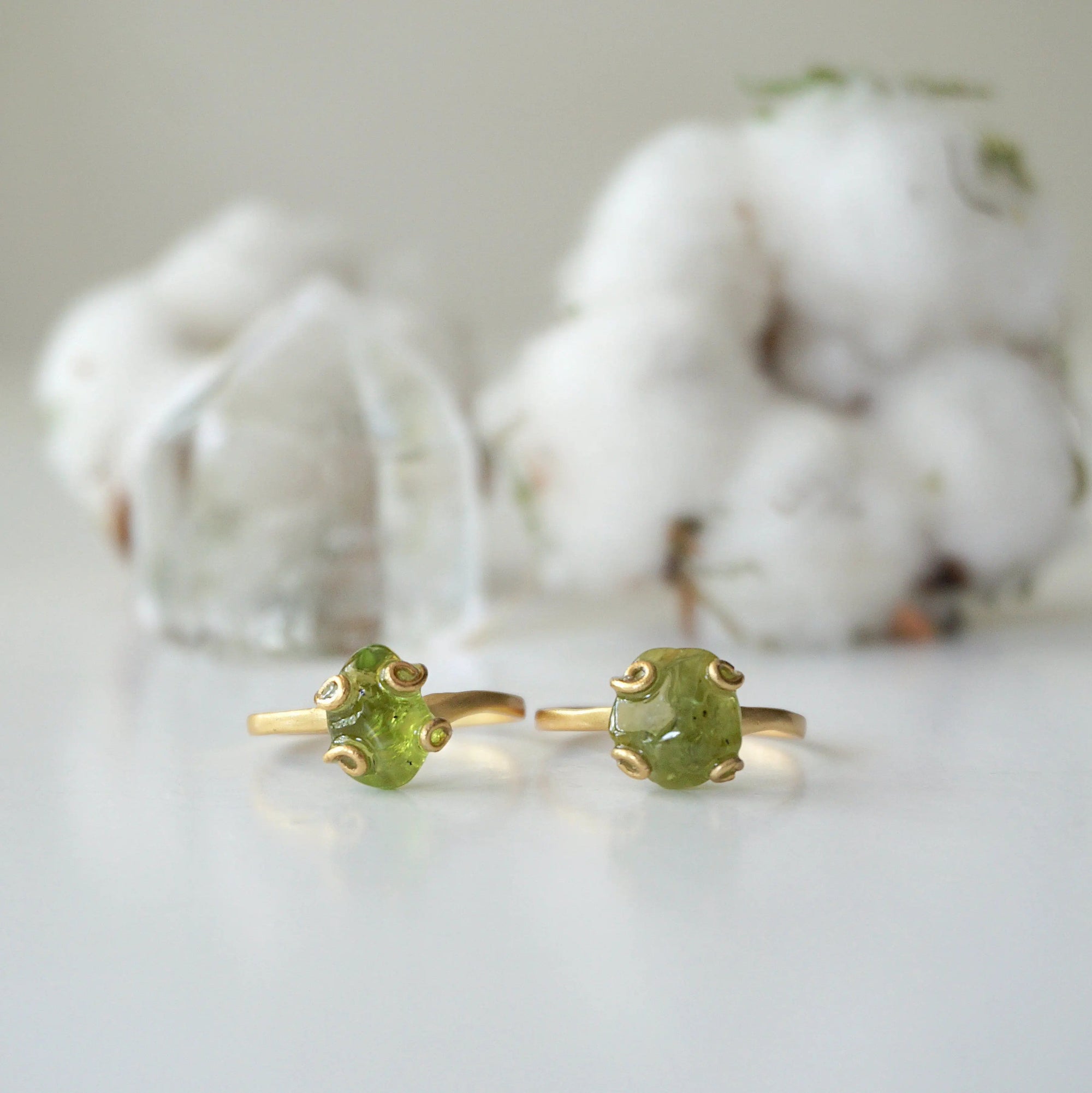 Two raw peridot adjustable rings showing natural variation in stone size, shape, and olive green colour — handcrafted 14k gold vermeil August birthstone crystal rings for women