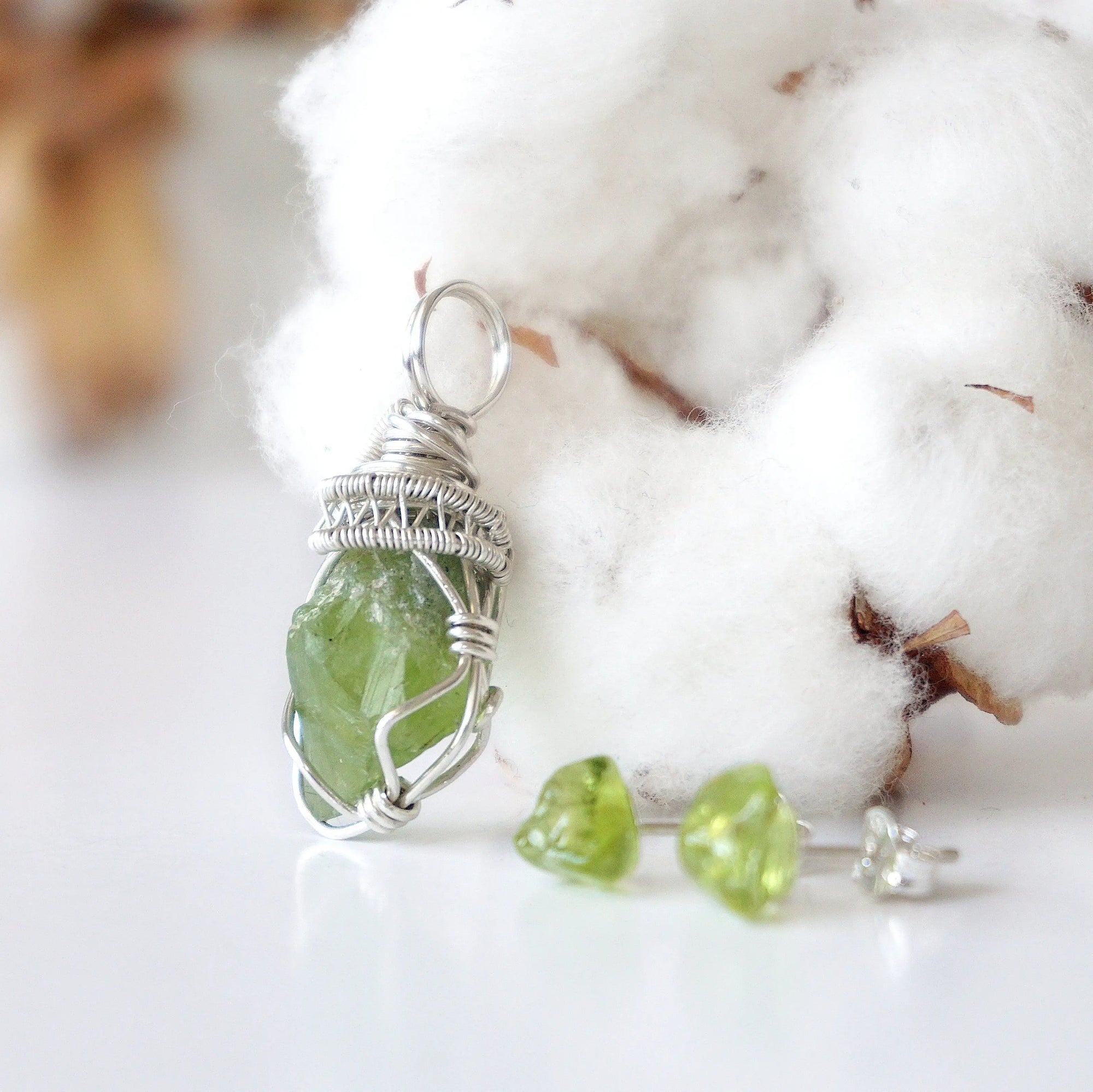 Left side detail of raw peridot pendant and stud earrings — 925 sterling silver coiled wire bail and lattice wrap detail, artisan crystal jewelry set for women