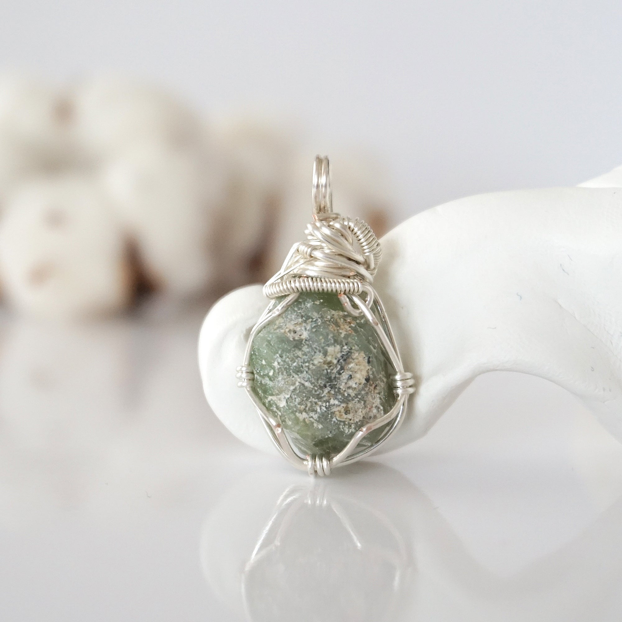 Back view of raw peridot wire wrapped pendant — silver finish hand-wrapped setting shows craftsmanship and secure stone hold, handmade in Toronto Canada