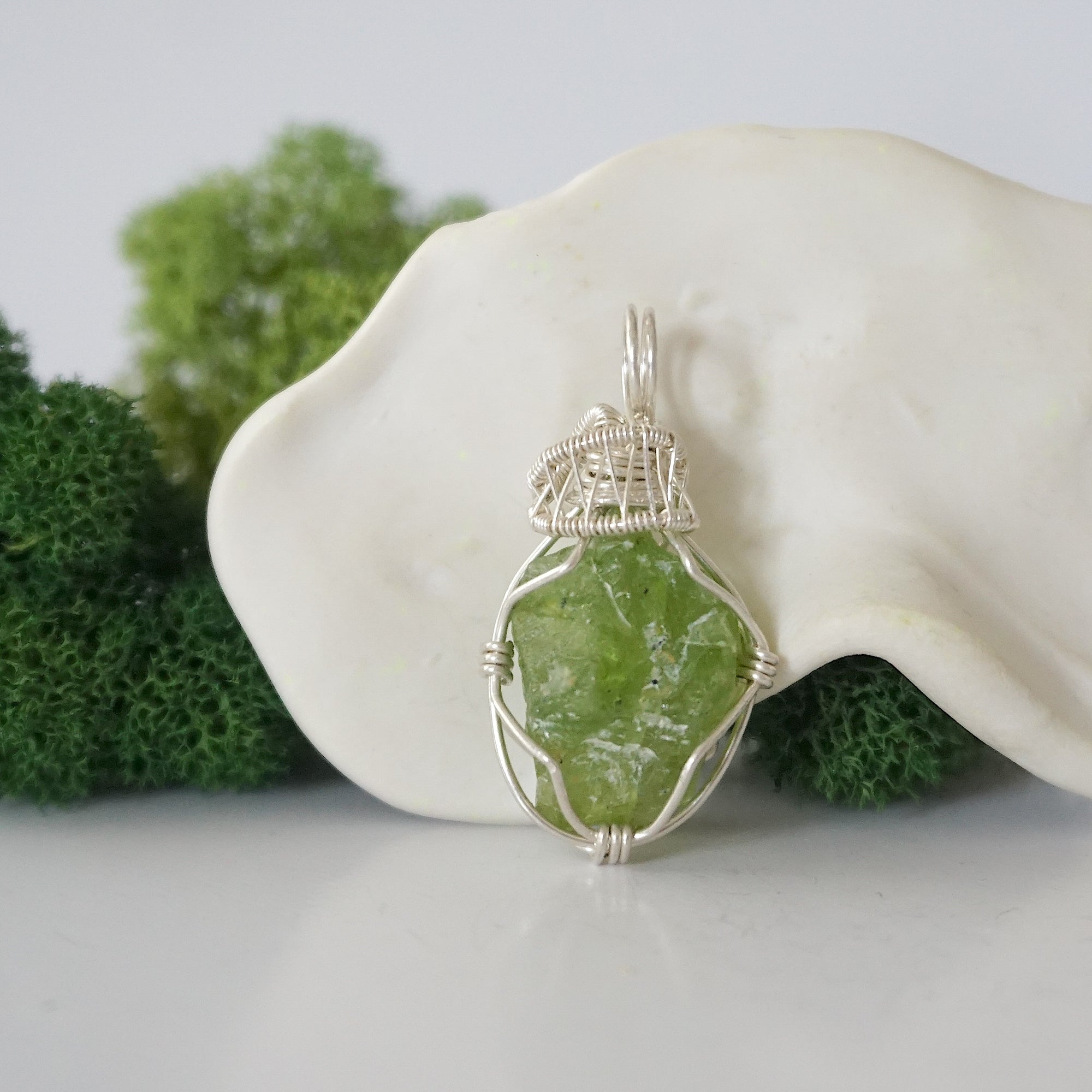 Front view of raw green peridot pendant — natural unpolished peridot stone hand-wrapped in detailed 925 sterling silver wire, handcrafted artisan jewelry
