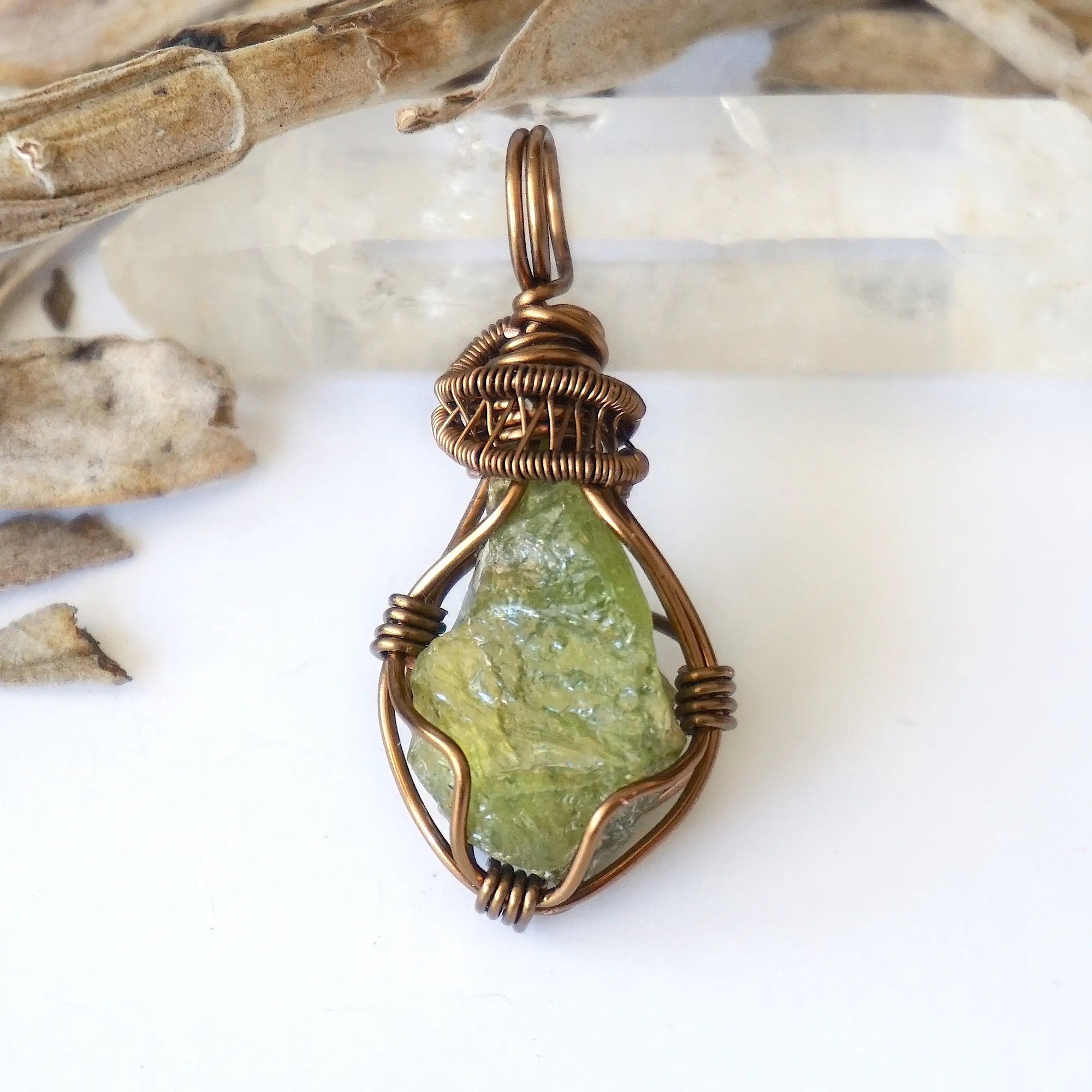 Front view of raw peridot pendant for women — vivid olive green crystal with natural surface texture, antique bronze wire wrap, handcrafted August birthstone jewelry