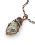 Front view of raw peridot necklace for women — soft sage olive green crystal with natural surface texture, antique bronze and dark silver wire wrap, handcrafted August birthstone jewelry