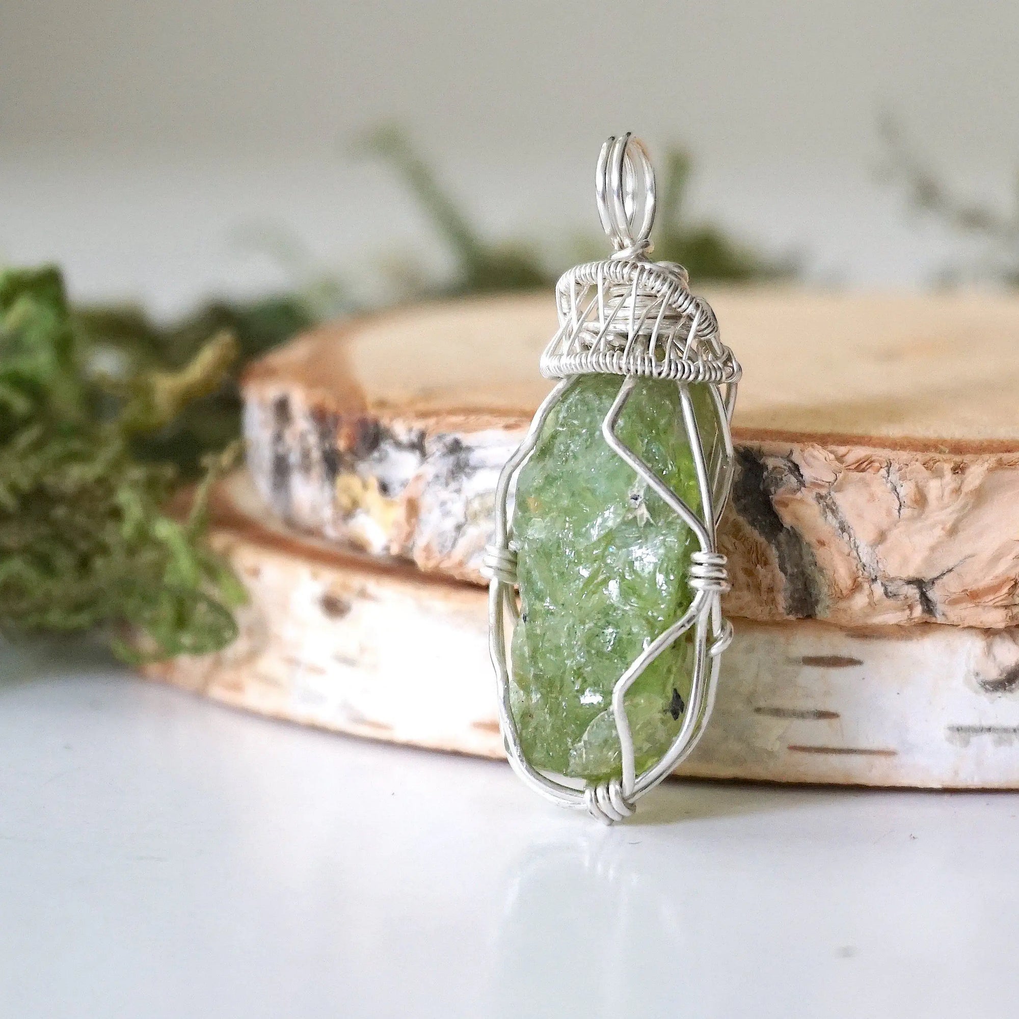 Left side detail of handmade raw peridot pendant for women — 925 sterling silver wire weave and coiled bail artistry, artisan crystal necklace by Designs by Nature Gems