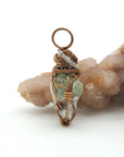 Right side detail of handmade raw peridot pendant — antique bronze and dark silver wire wrapping technique, artisan crystal jewelry for women