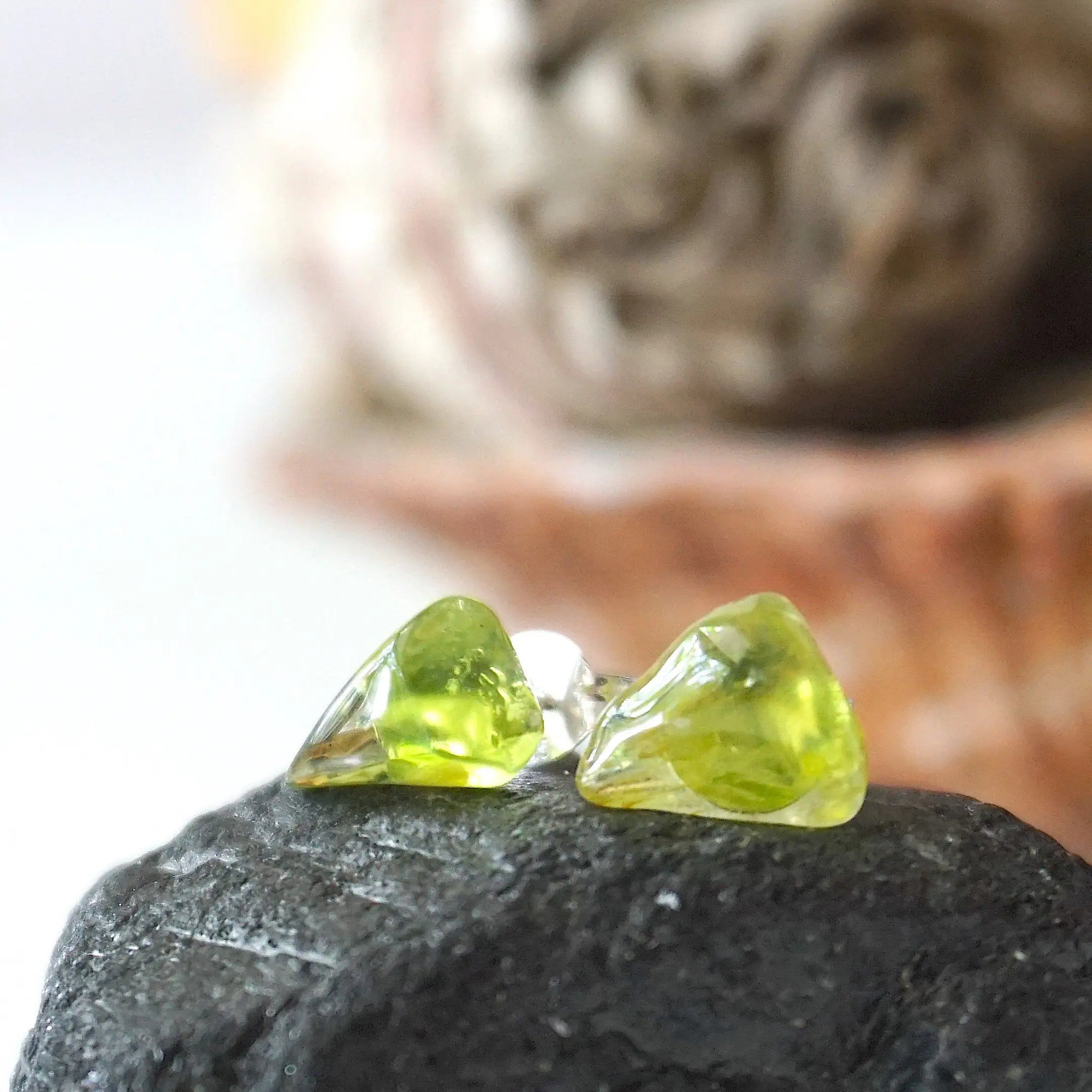 Front view of raw peridot stud earrings — vivid translucent olive green natural crystal on sterling silver posts, dainty handcrafted August birthstone earrings by Designs by Nature Gems