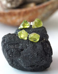 Two pairs of raw peridot stud earrings showing natural variation in stone shape, size, and olive green colour — handcrafted 925 sterling silver August birthstone crystal studs by Designs by Nature Gems