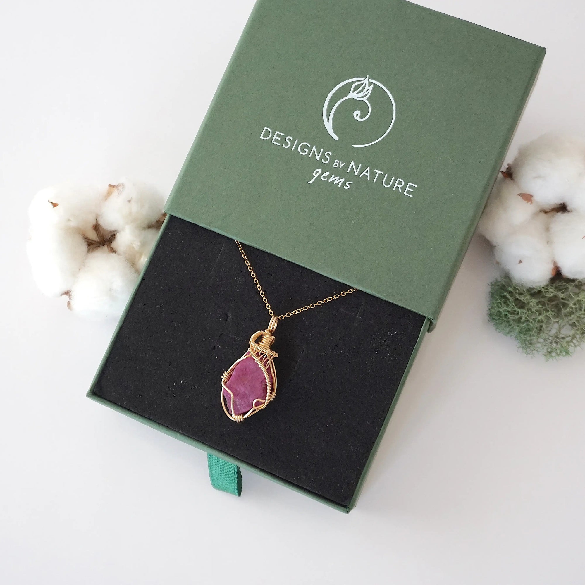 Raw pink ruby necklace in 14k gold filled displayed in branded Designs by Nature Gems jewelry box. Artisan July birthstone gift for women.