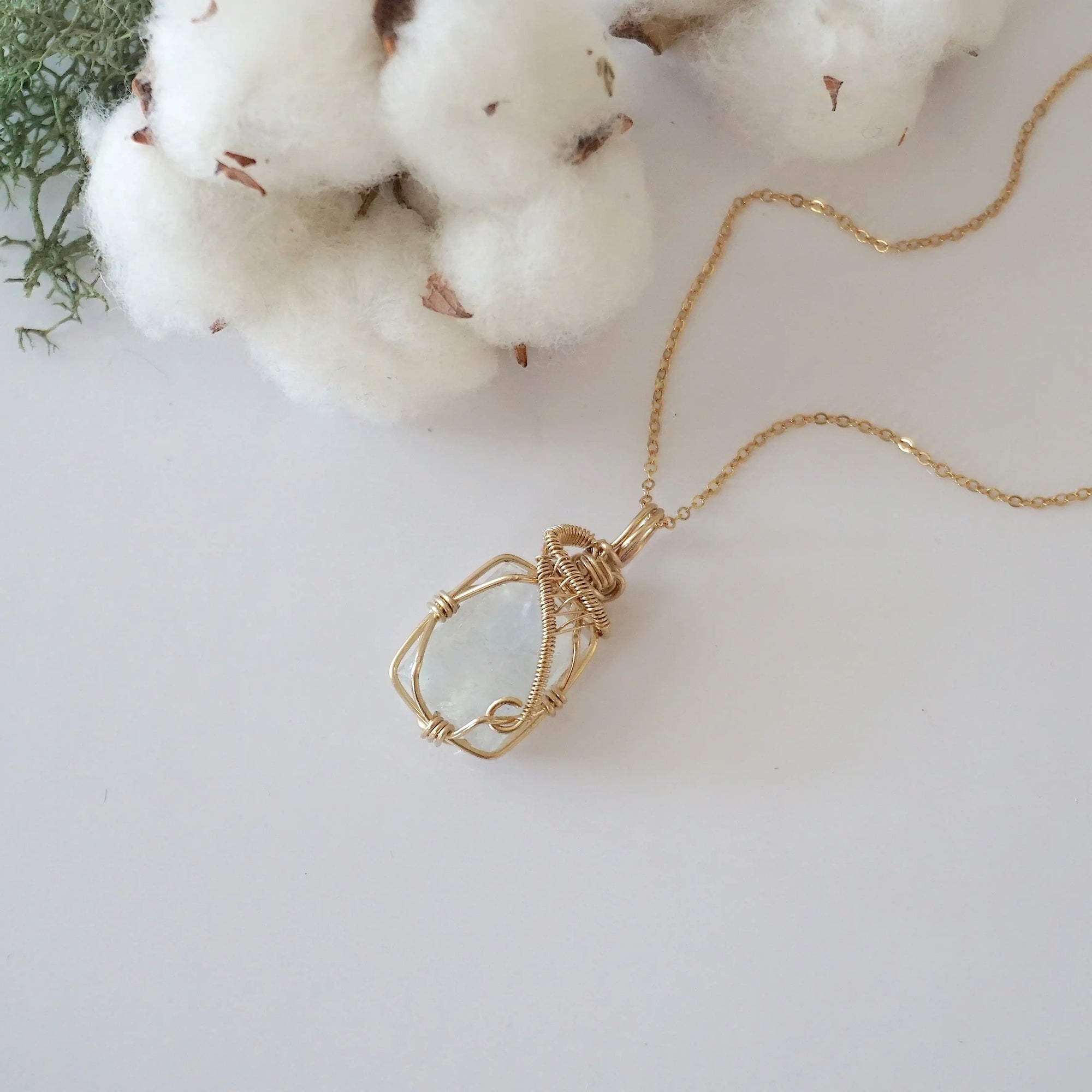 Raw rainbow moonstone necklace in 14k gold filled laying flat. Handcrafted June birthstone jewelry for women by Designs by Nature Gems.