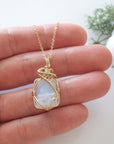 Raw rainbow moonstone necklace in 14k gold filled shown in hand for size reference. Artisan June birthstone pendant by Designs by Nature Gems.