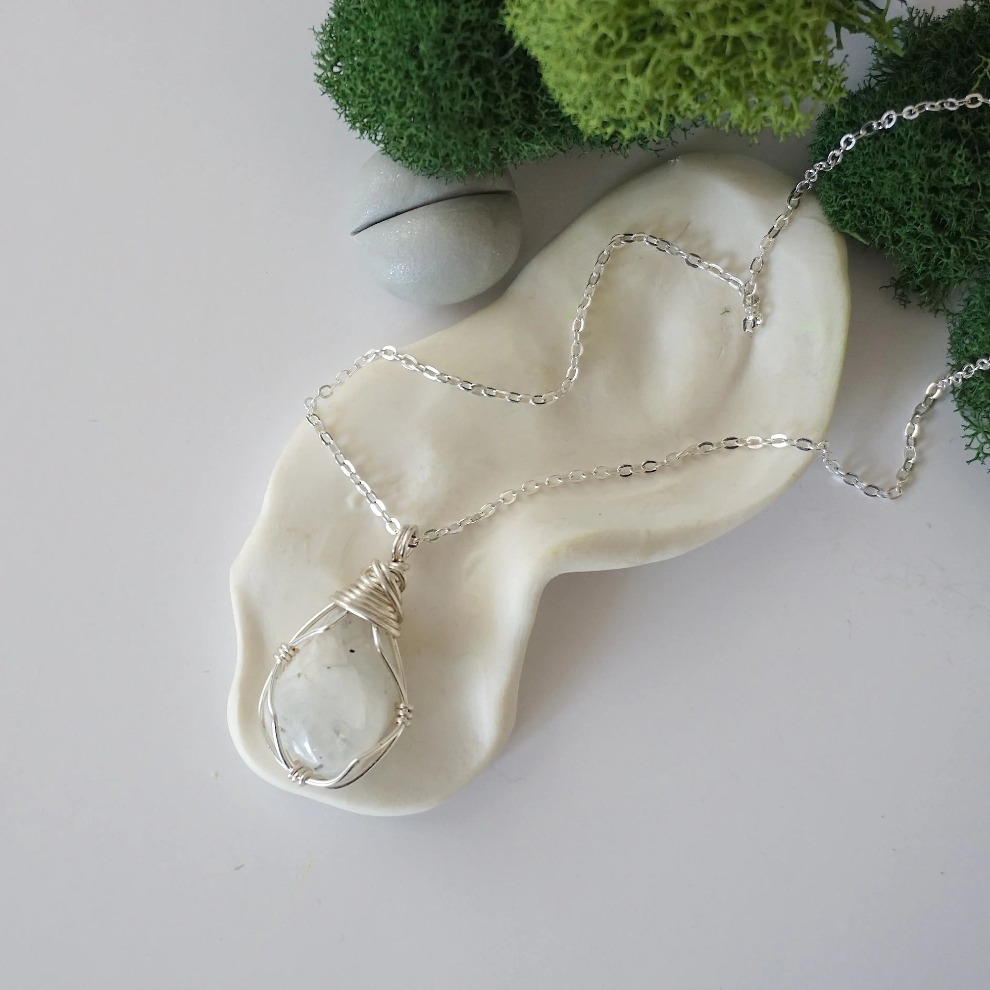 Simple raw rainbow moonstone necklace with silver plated brass chain laying flat
