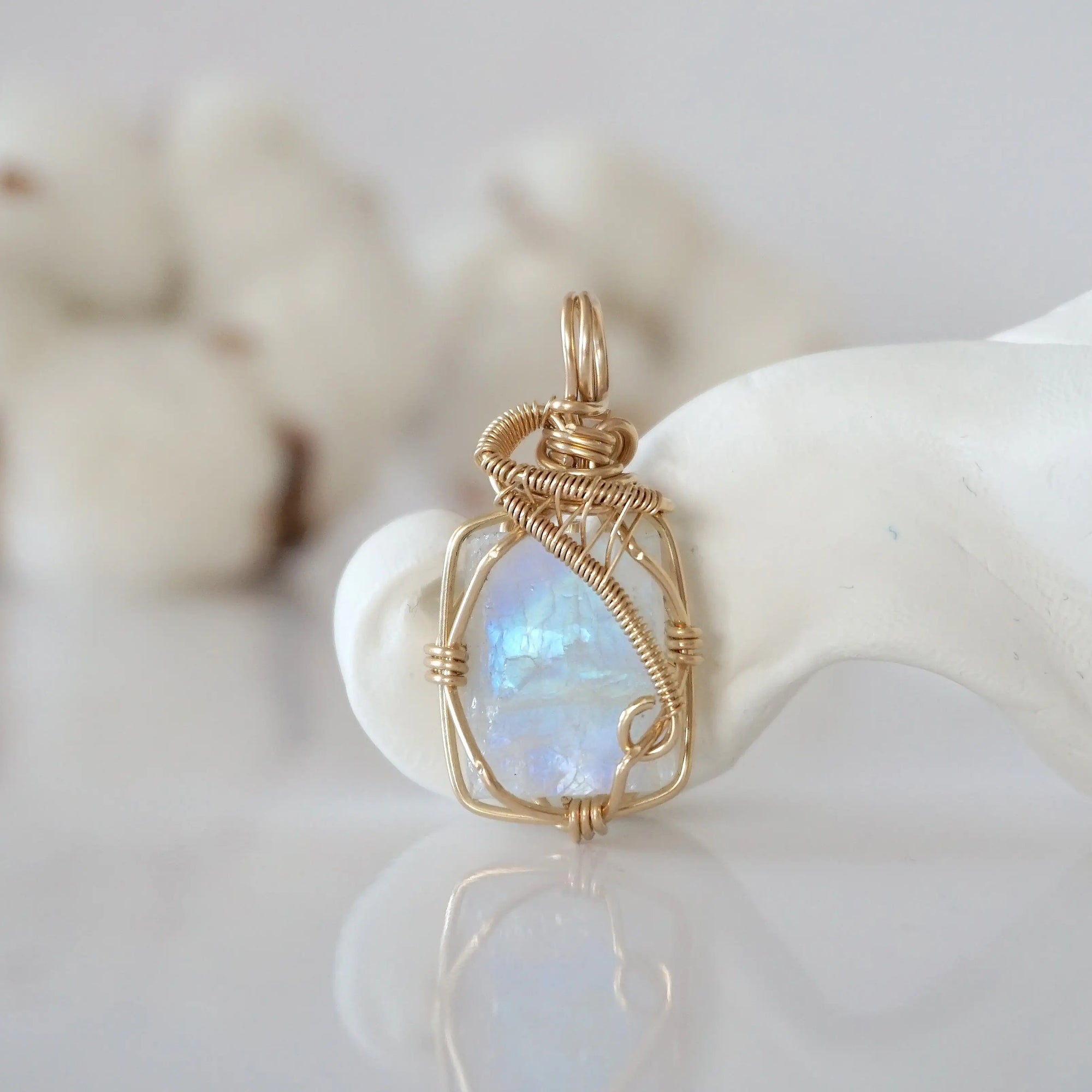 Detailed front view of raw rainbow moonstone pendant in 14k gold filled. Unique wire wrapped June birthstone jewelry by Designs by Nature Gems.