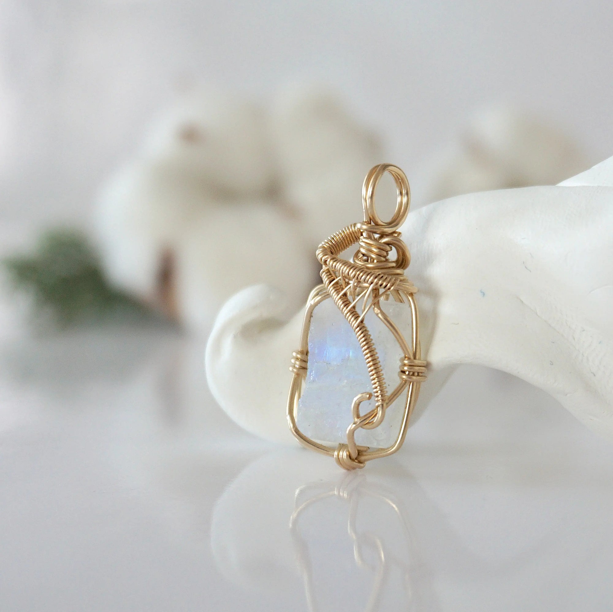 Side view of raw rainbow moonstone pendant in 14k gold filled, showing artisan wire wrapping. Handcrafted June birthstone necklace by Designs by Nature Gems.