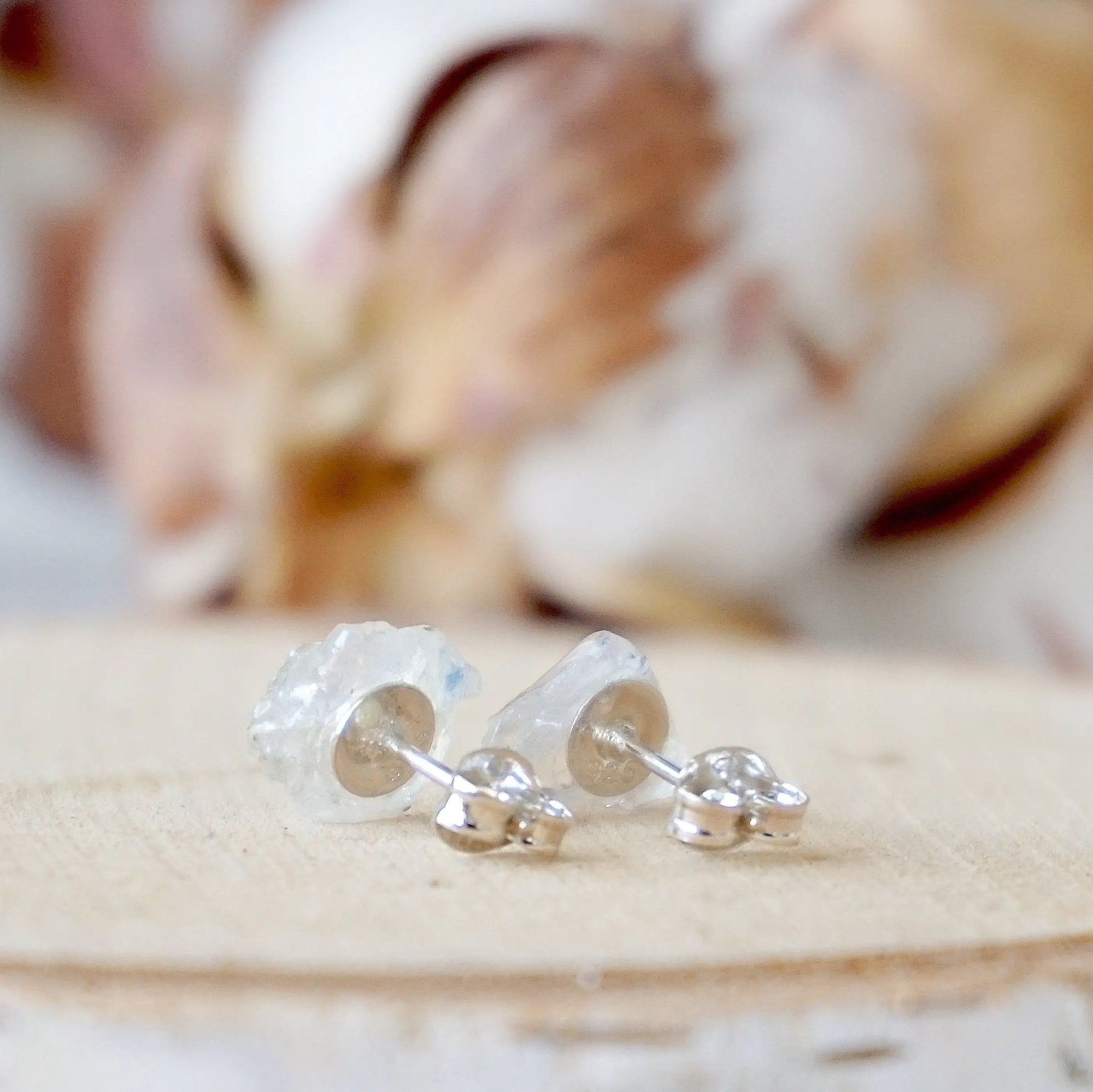 Back view of raw rainbow moonstone stud earrings showing 925 sterling silver posts and backs, minimalist June birthstone studs.