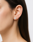 Model wearing raw rainbow moonstone stud earrings on 925 sterling silver posts, minimalist June birthstone earrings for everyday wear.