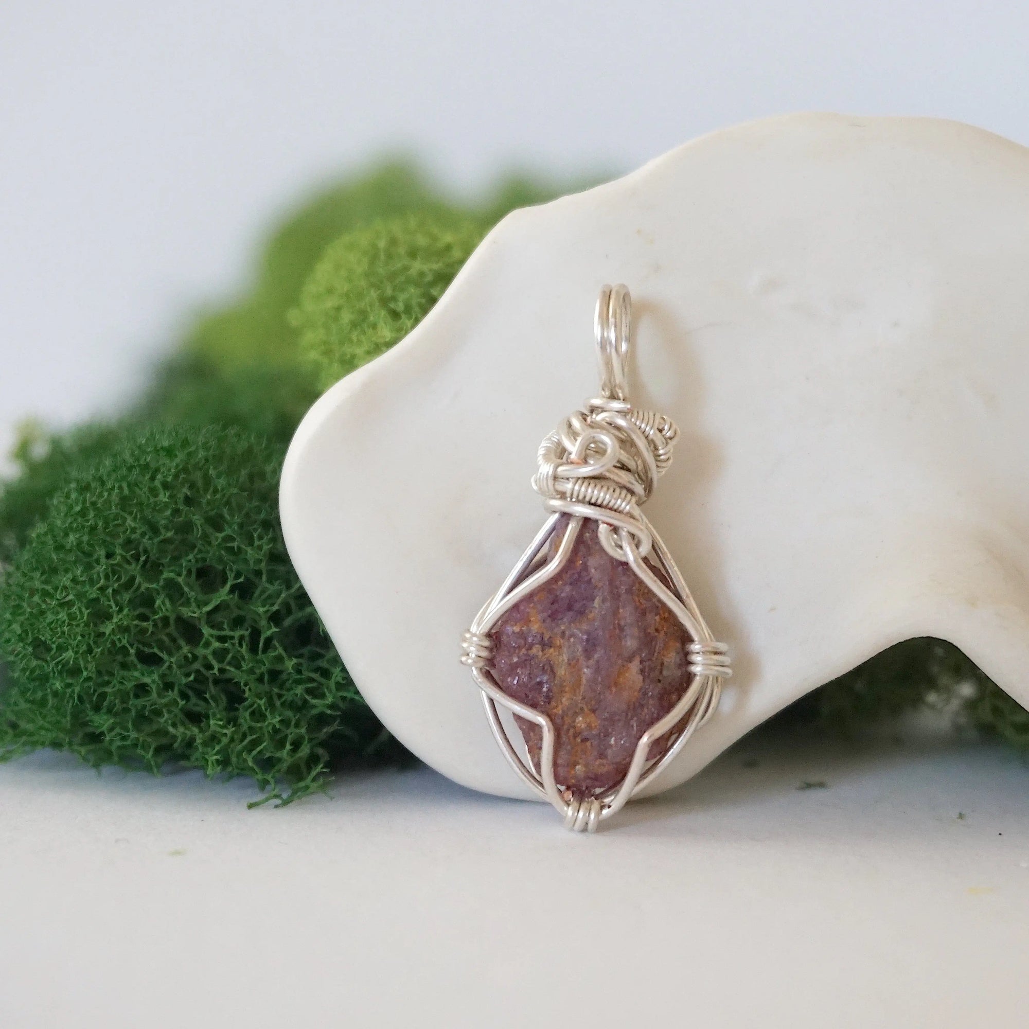 Back angle of raw ruby pendant displaying silver wire wrapping craftsmanship — handmade artisan crystal jewelry, nickel-free copper wire