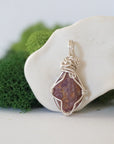 Back angle of raw ruby pendant displaying silver wire wrapping craftsmanship — handmade artisan crystal jewelry, nickel-free copper wire